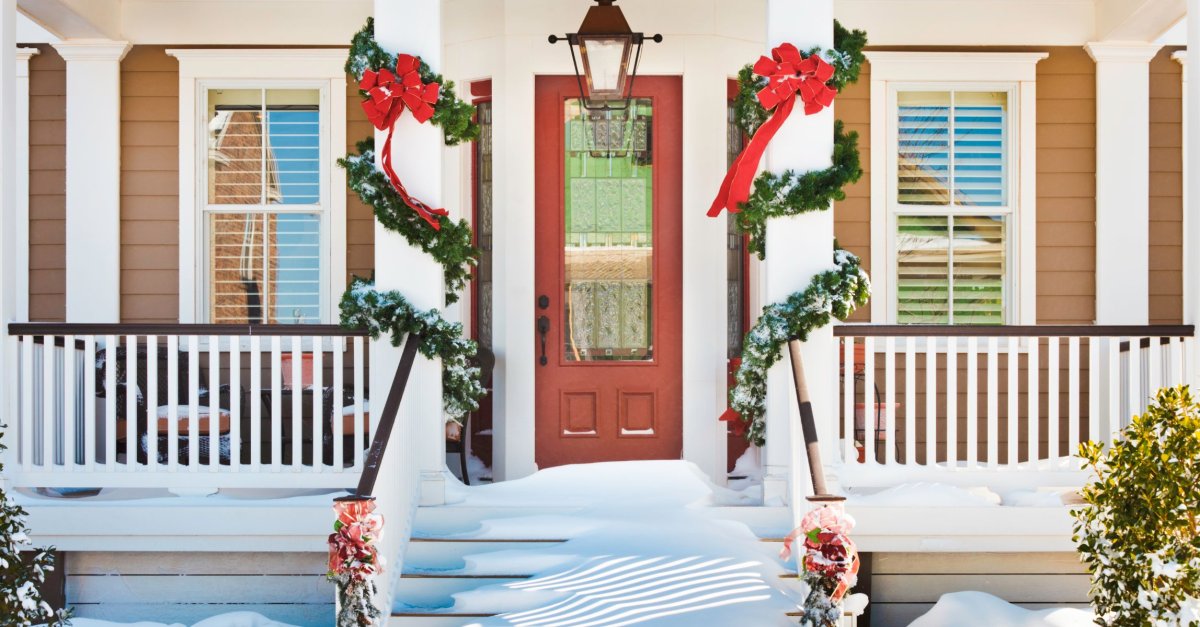 Inviting doorway with snow on porch stairs and railing