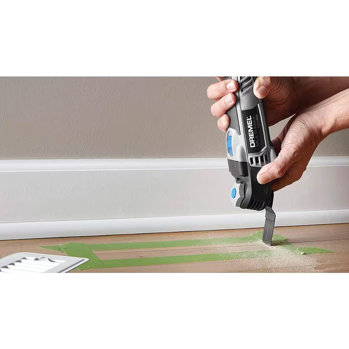A person making a plunge cut in hardwood flooring using an oscillating tool.