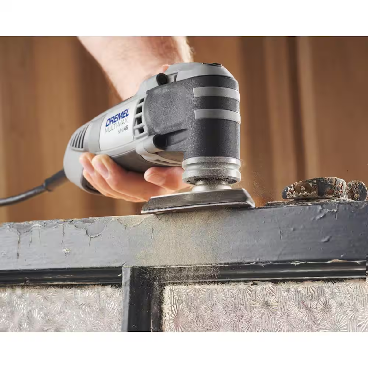A person sanding furniture with an oscillating tool.