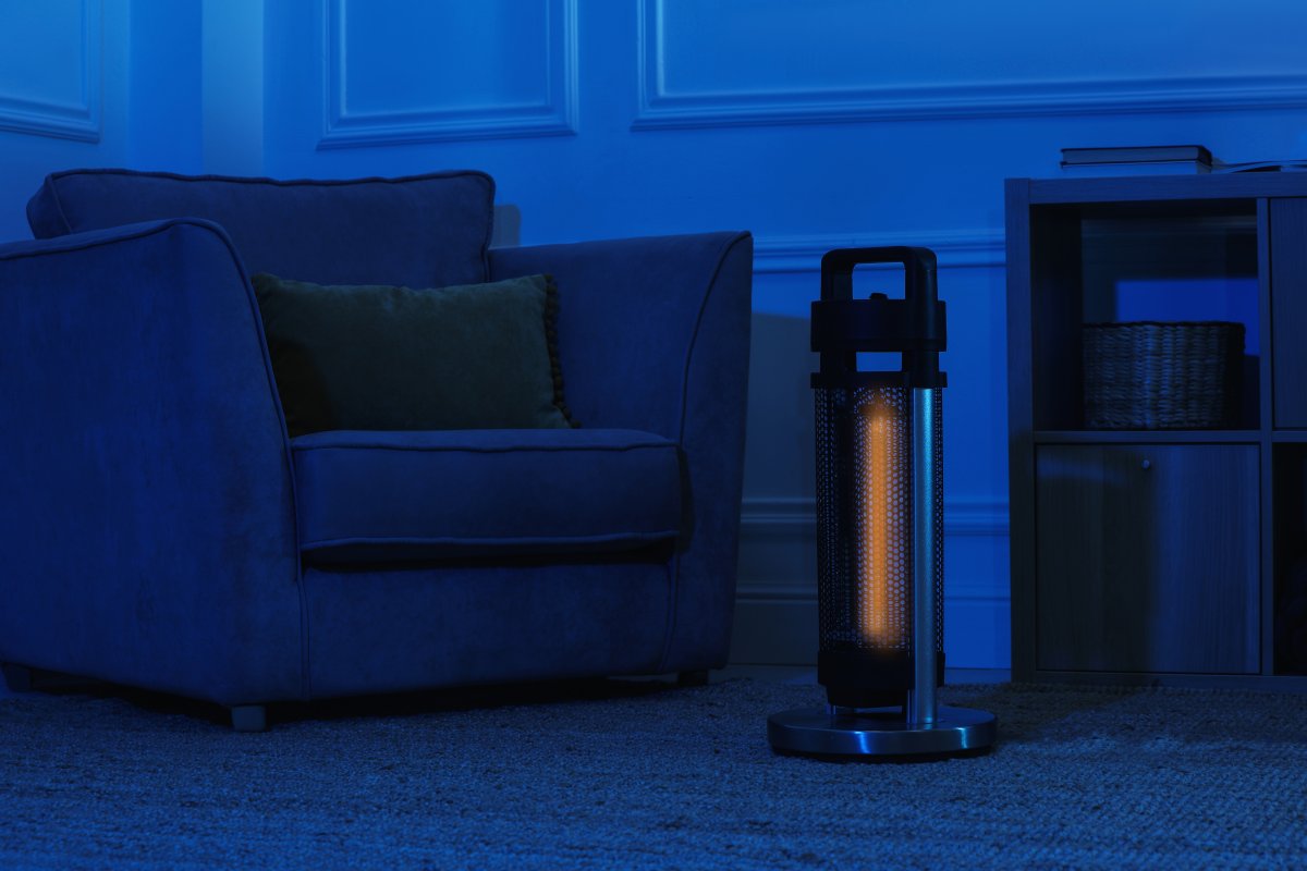 Electric infrared heater in dark living room at night