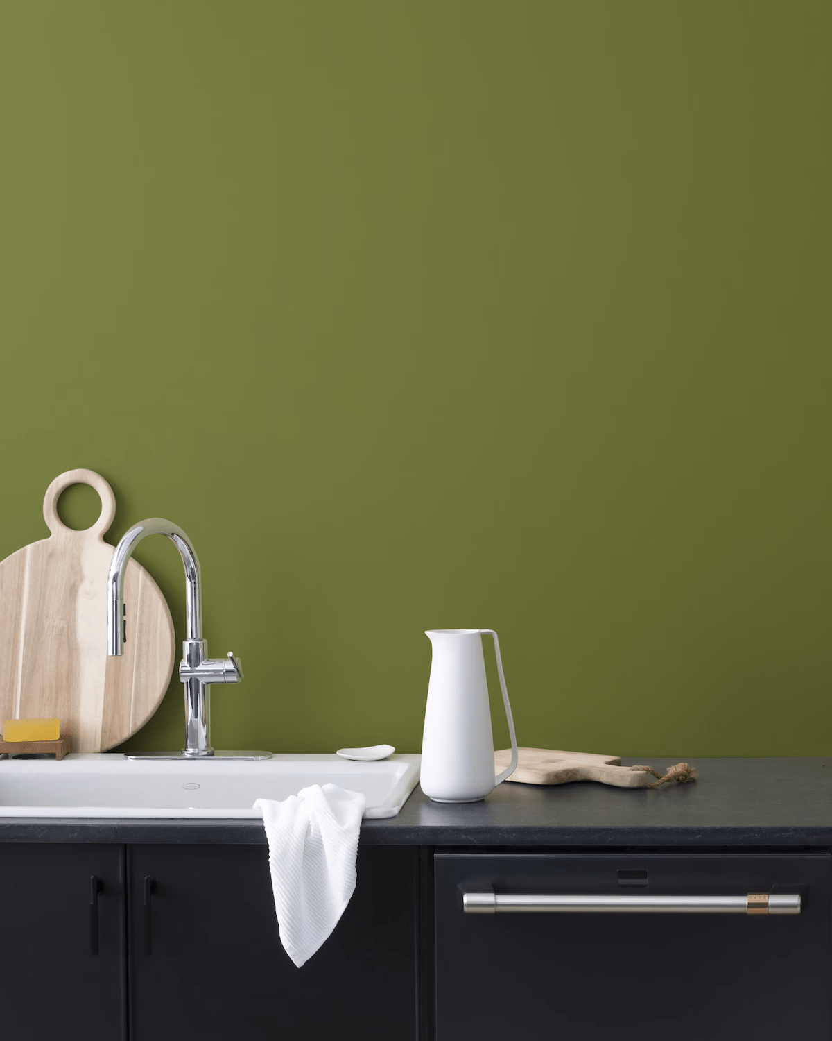Avocado, one of the best green paint colors from Benjamin Moore, painted on a kitchen wall.