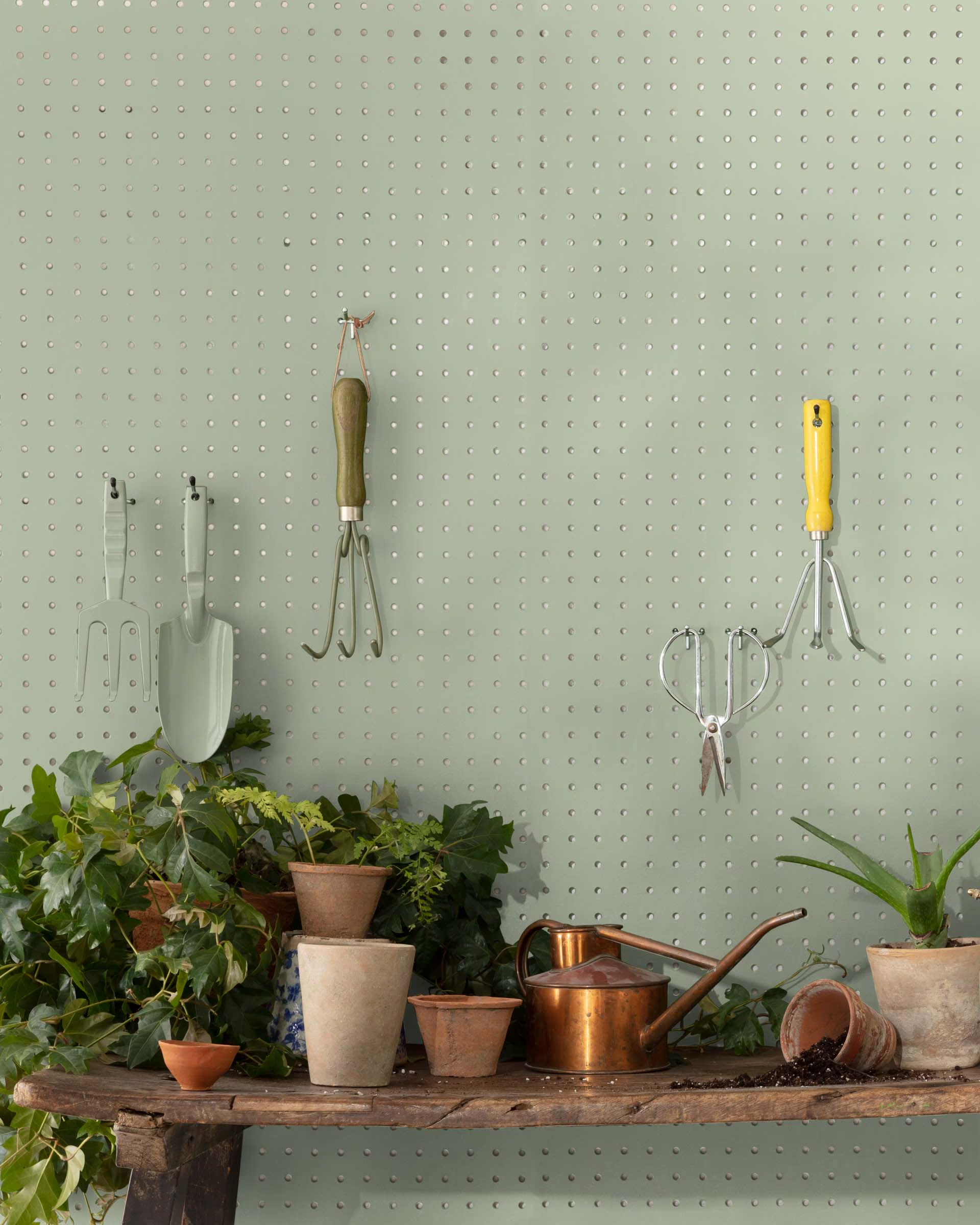 A pegboard painted Saybrook Sage from Benjamin Moore, one of the best green paint colors for home interiors.
