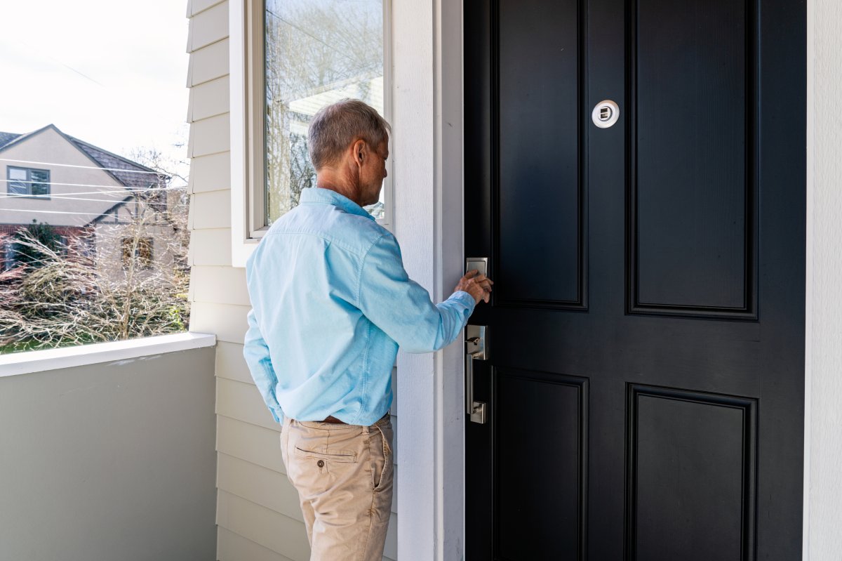 A man unlocking his front door with a smart keypad.