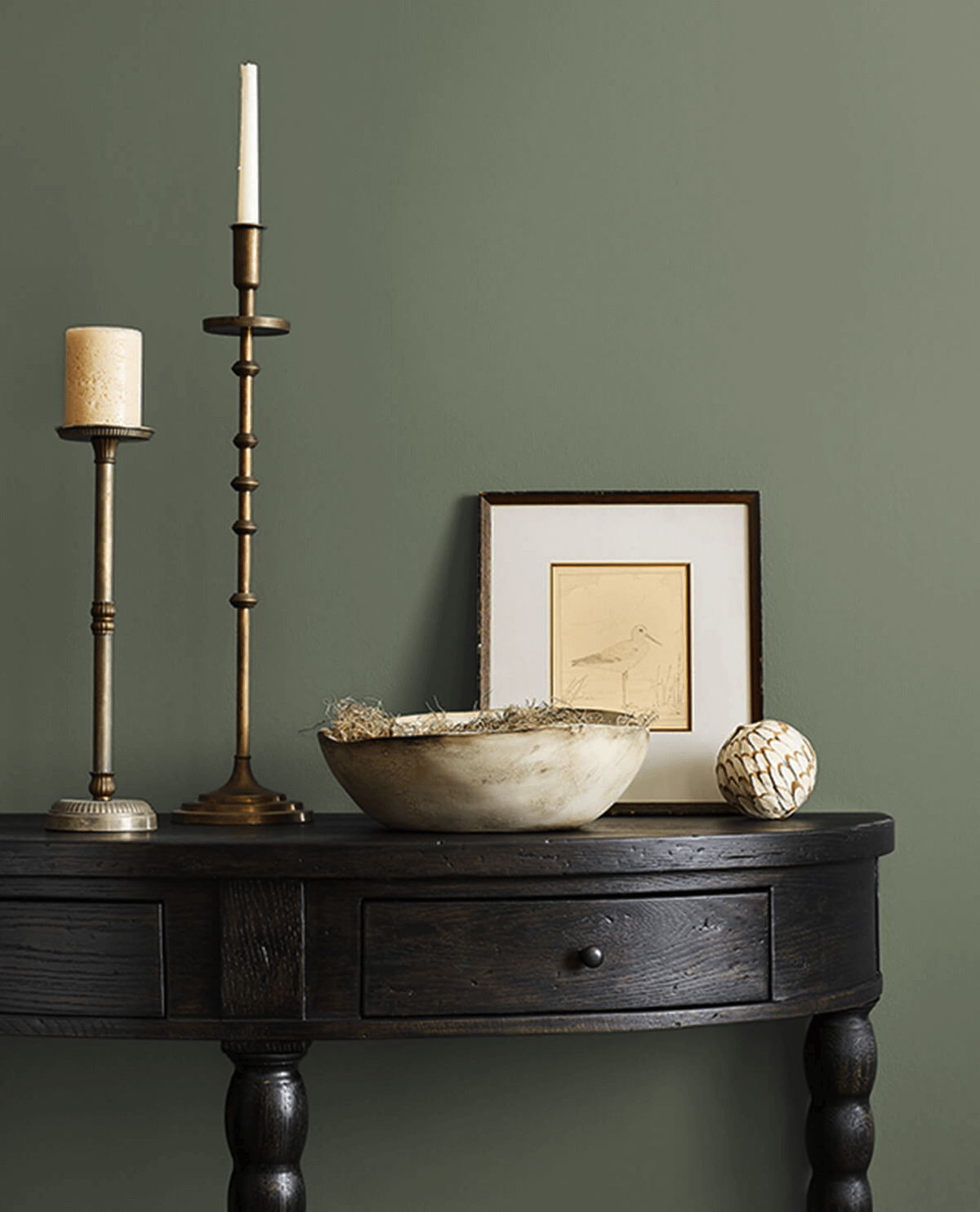 A living room wall painted in Sherwin-Williams Dried Thyme, one of the best green paint colors.