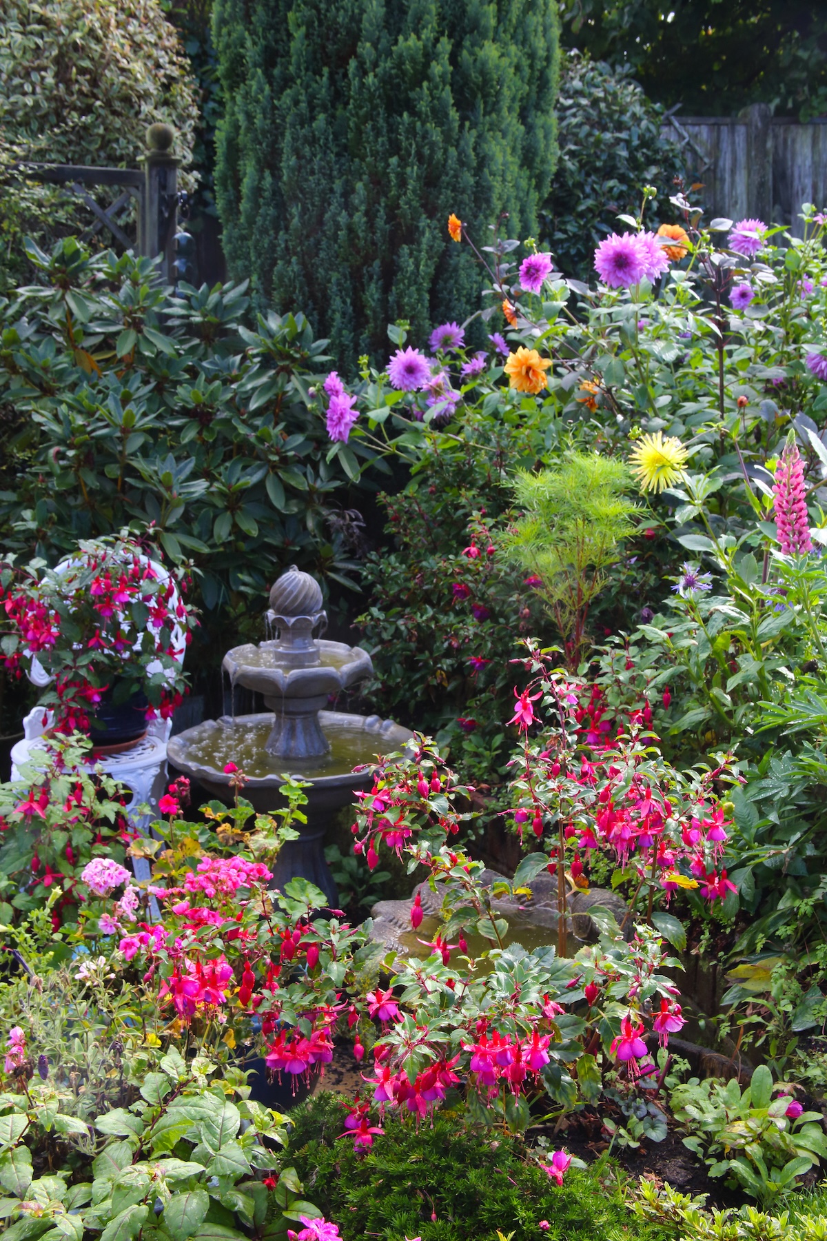 A beautiful flower bed anchored by a water fountain.