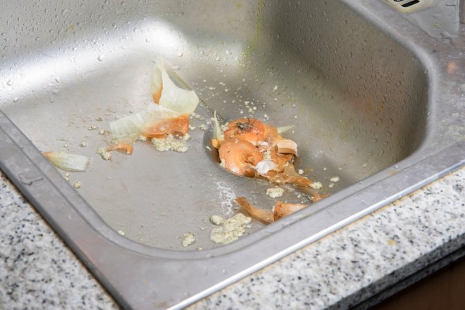 A garbage disposal clogged with food scraps.