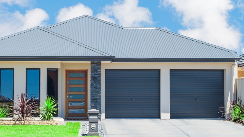 A modern home with a black metal roof.
