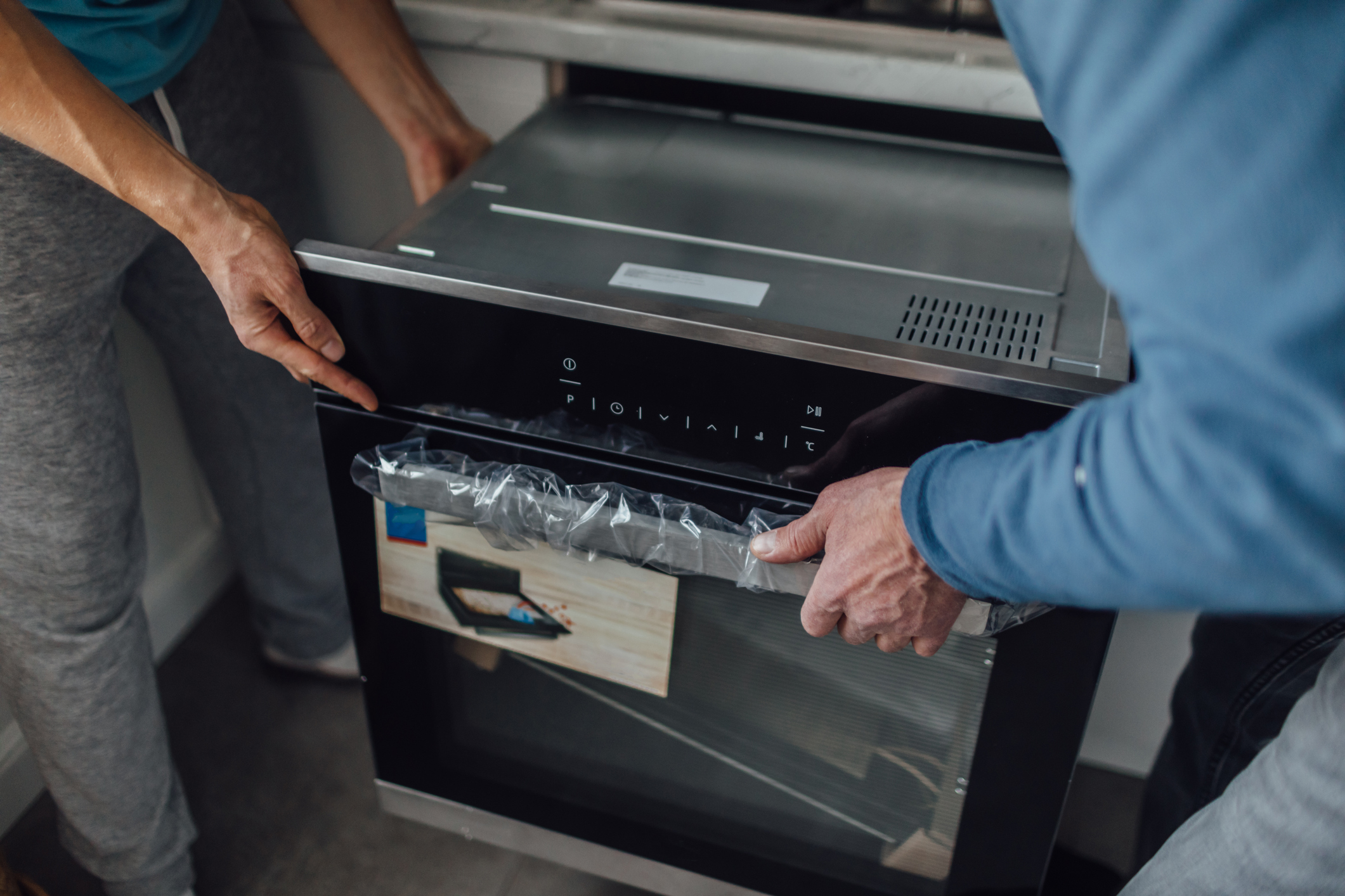 Two men installing a new dishwasher.