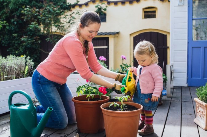 A mom and daughter potting up tomato plants to grow at home this summer.