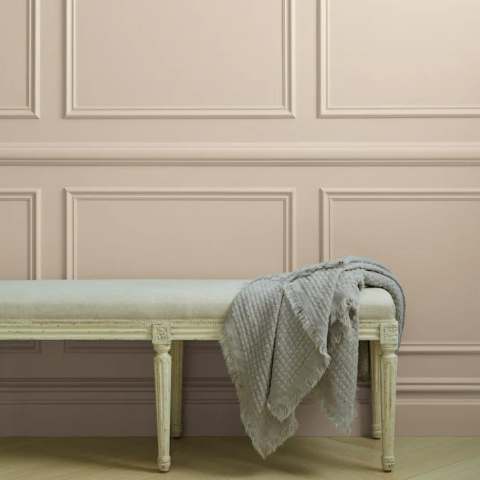 Clare paints Neutral Territory on a decorative wall.