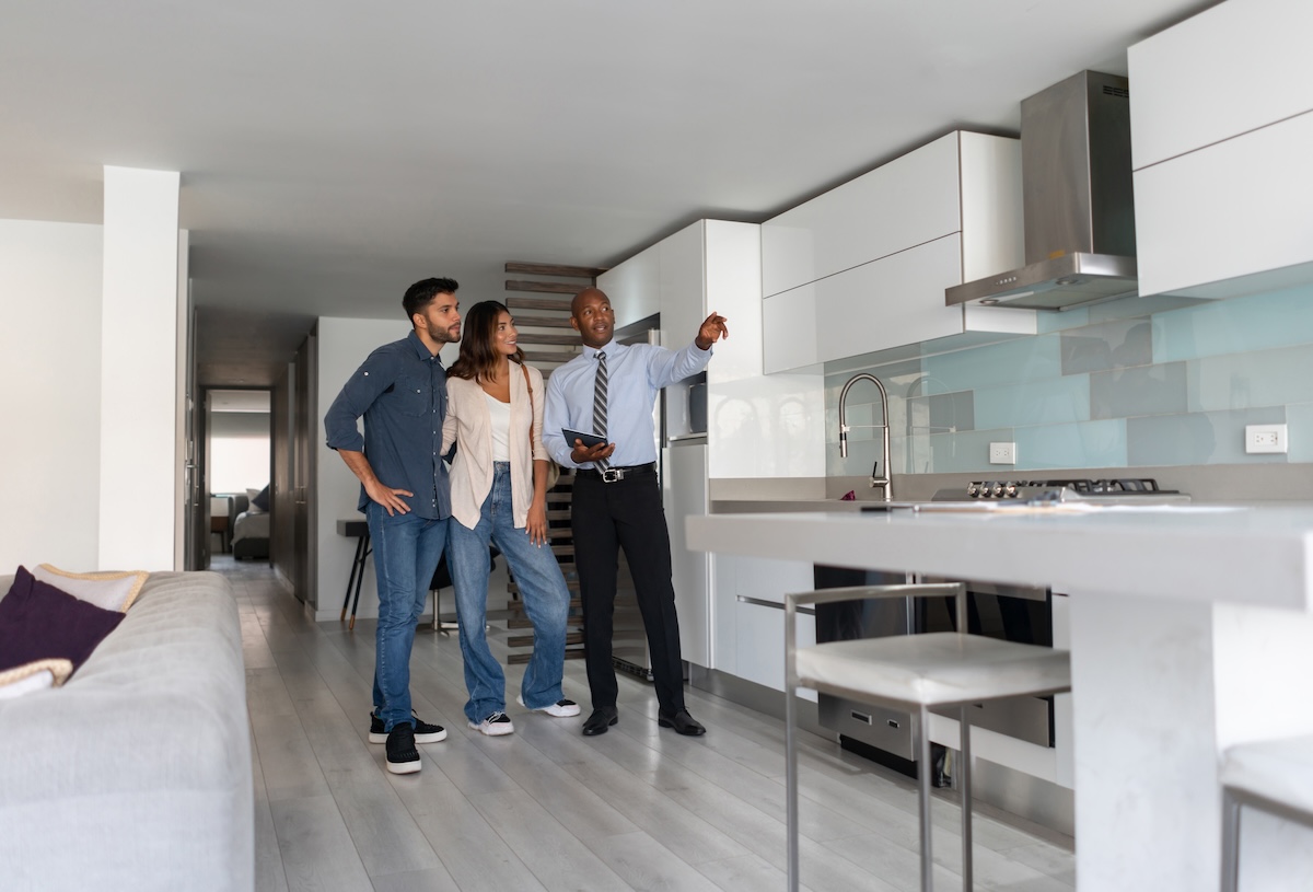 A real estate agent selling remodeled kitchen to home buyers.