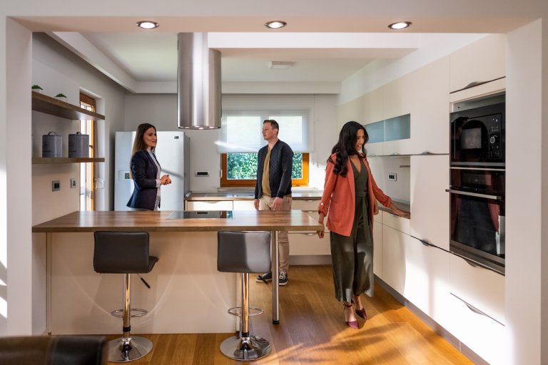A couple viewing a home with a remodeled kitchen.