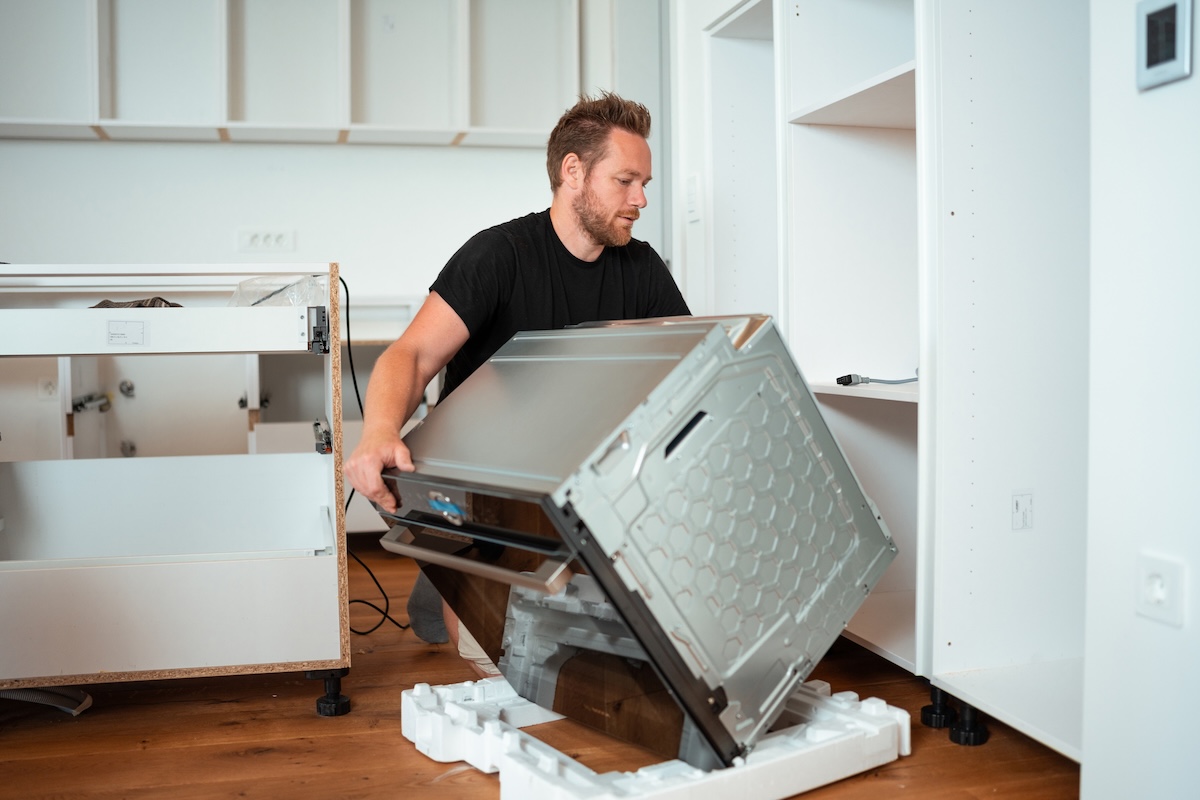 A homeowner installing a new energy-efficient oven in a small kitchen remodel.