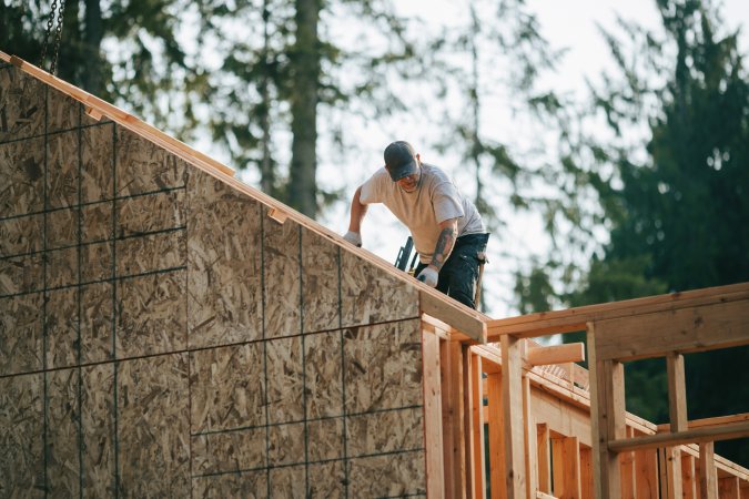 Worker building the wooden frame of a new house.