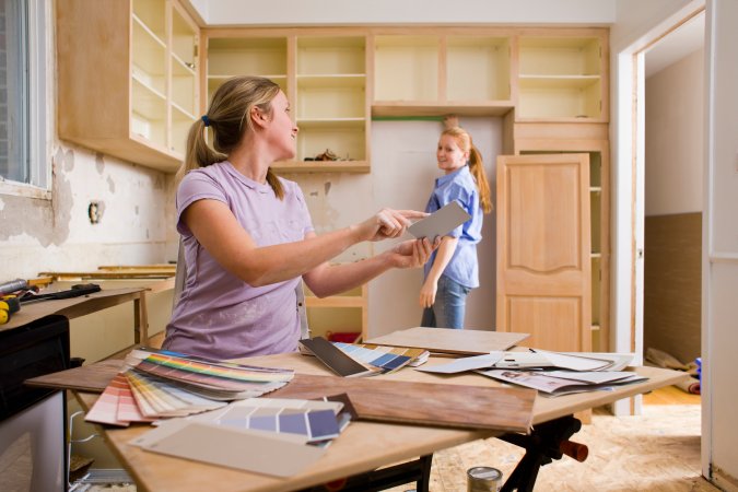 Two women in a kitchen under construction.