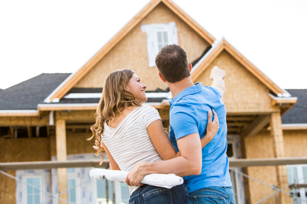Couple admiring new house under construction