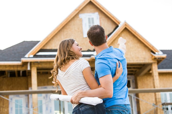 Couple admiring new house under construction