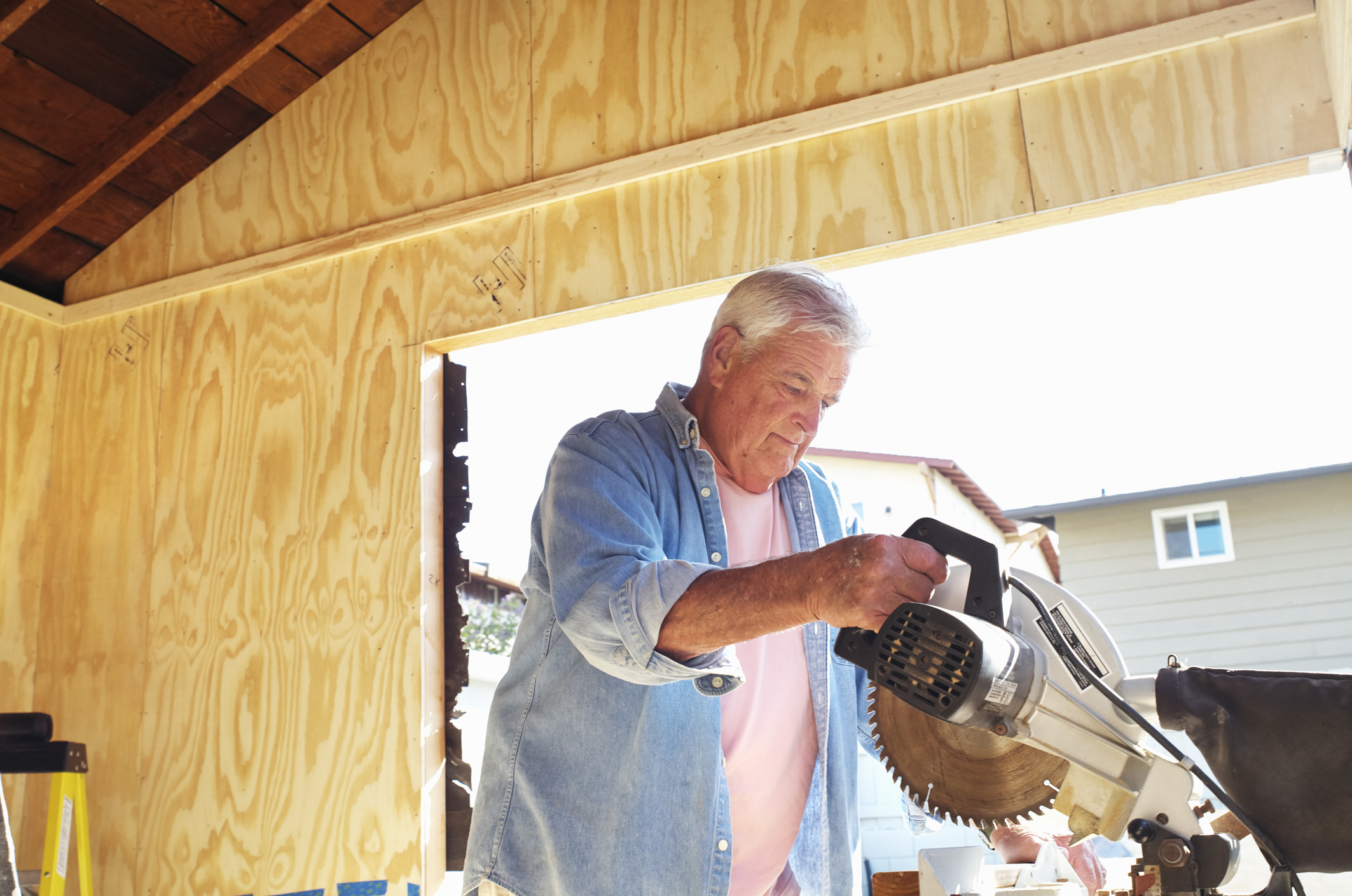 Man using a circular saw in a garage