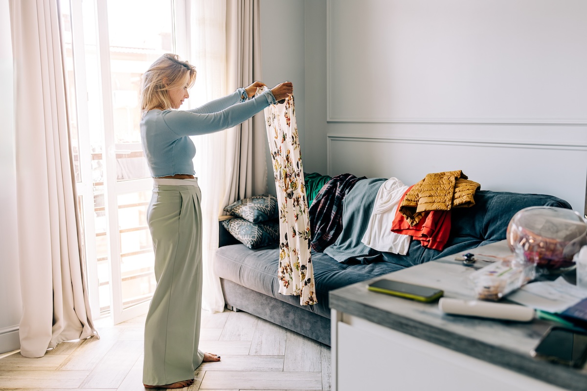 A woman cleans out clothing from her closet for donation.