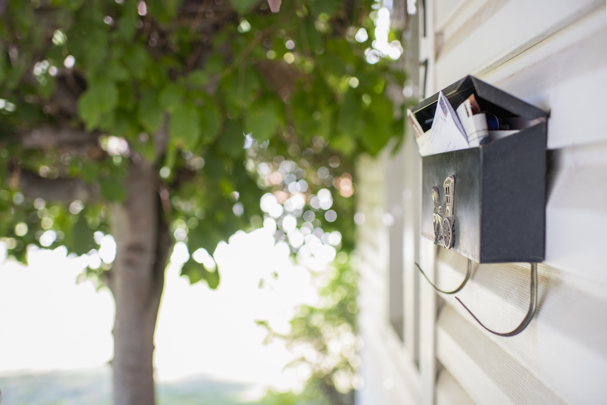 A front door mailbox full of junk mail.