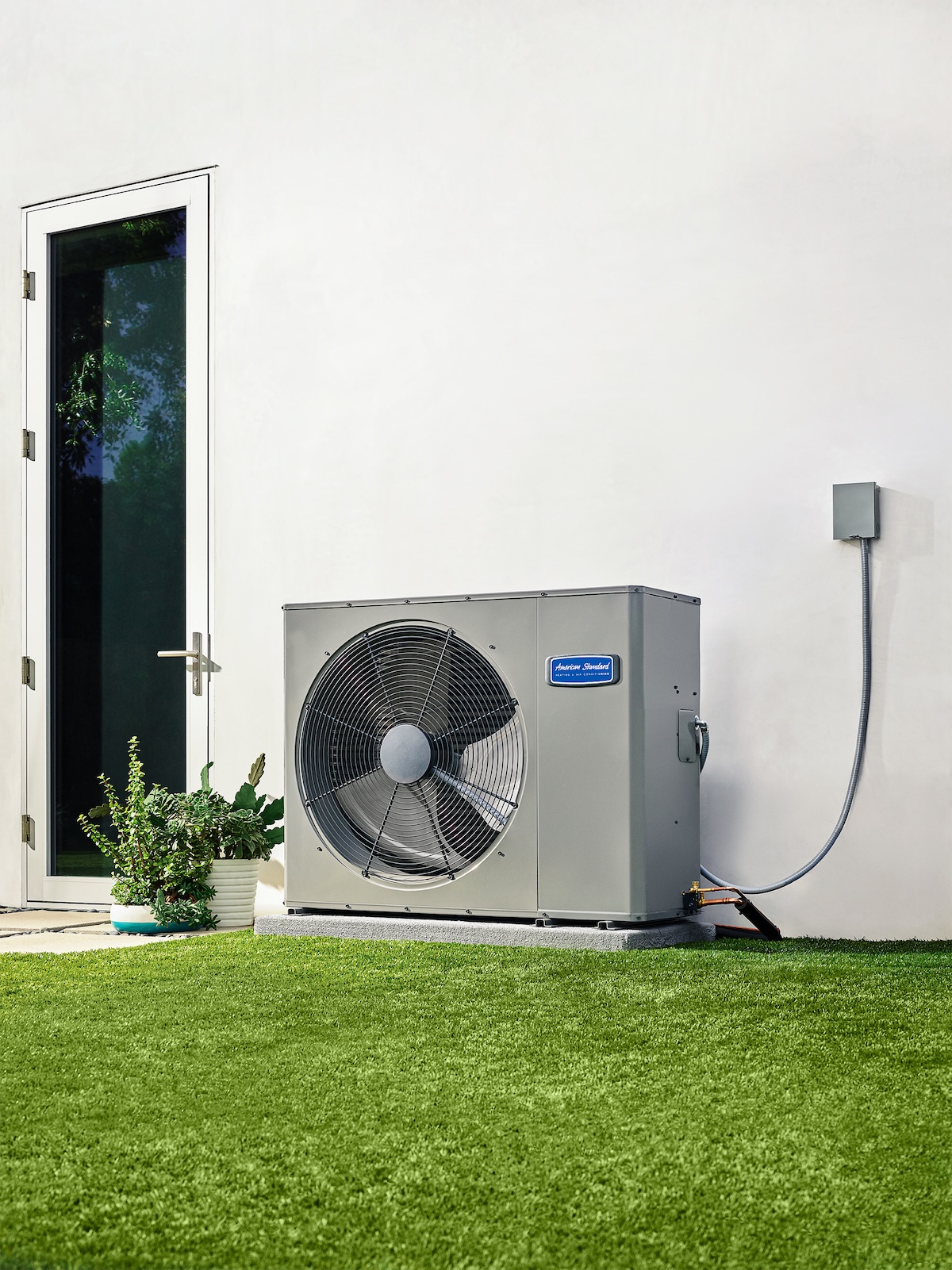 A modern home with a heat pump installed along the exterior.