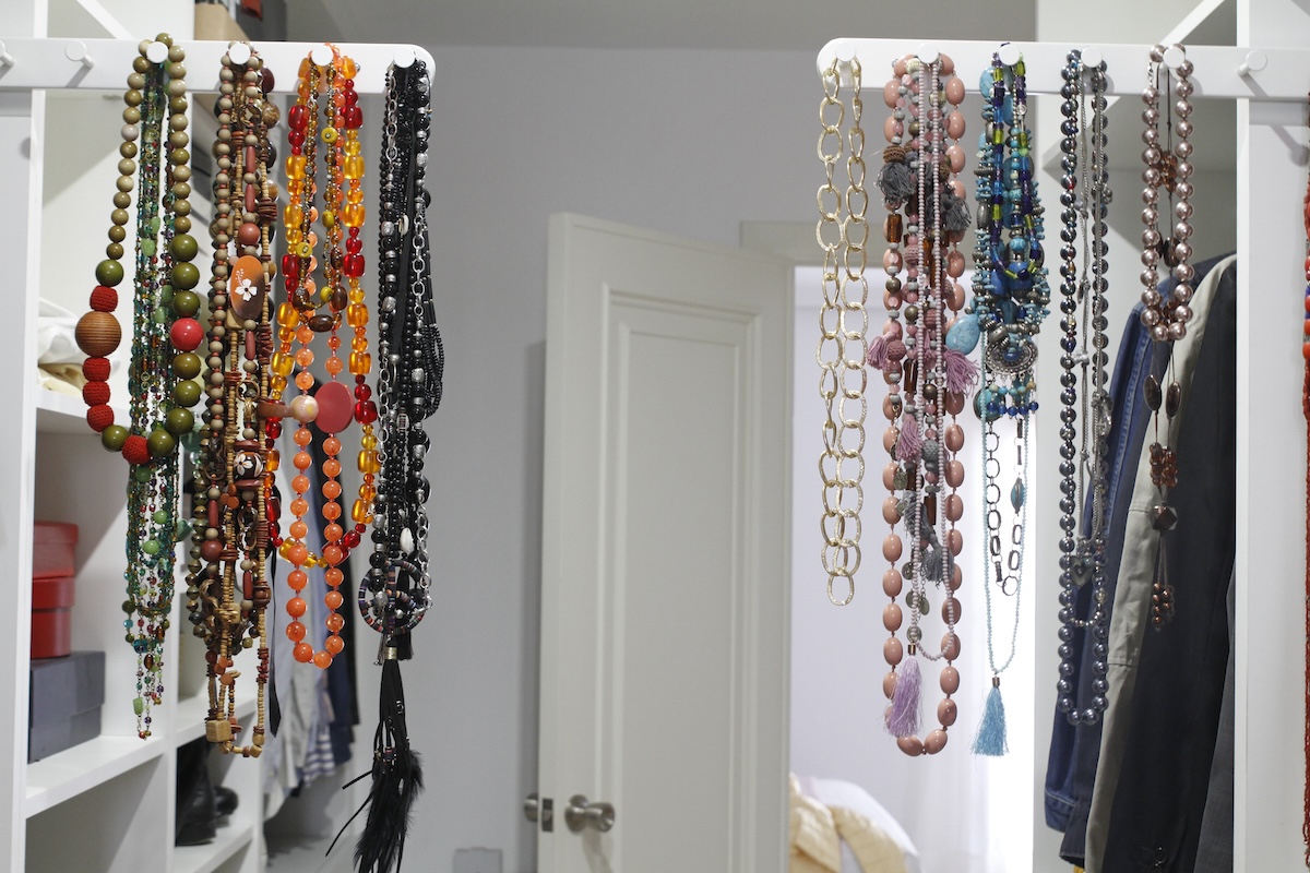 Necklaces hanging on a decorative rack.