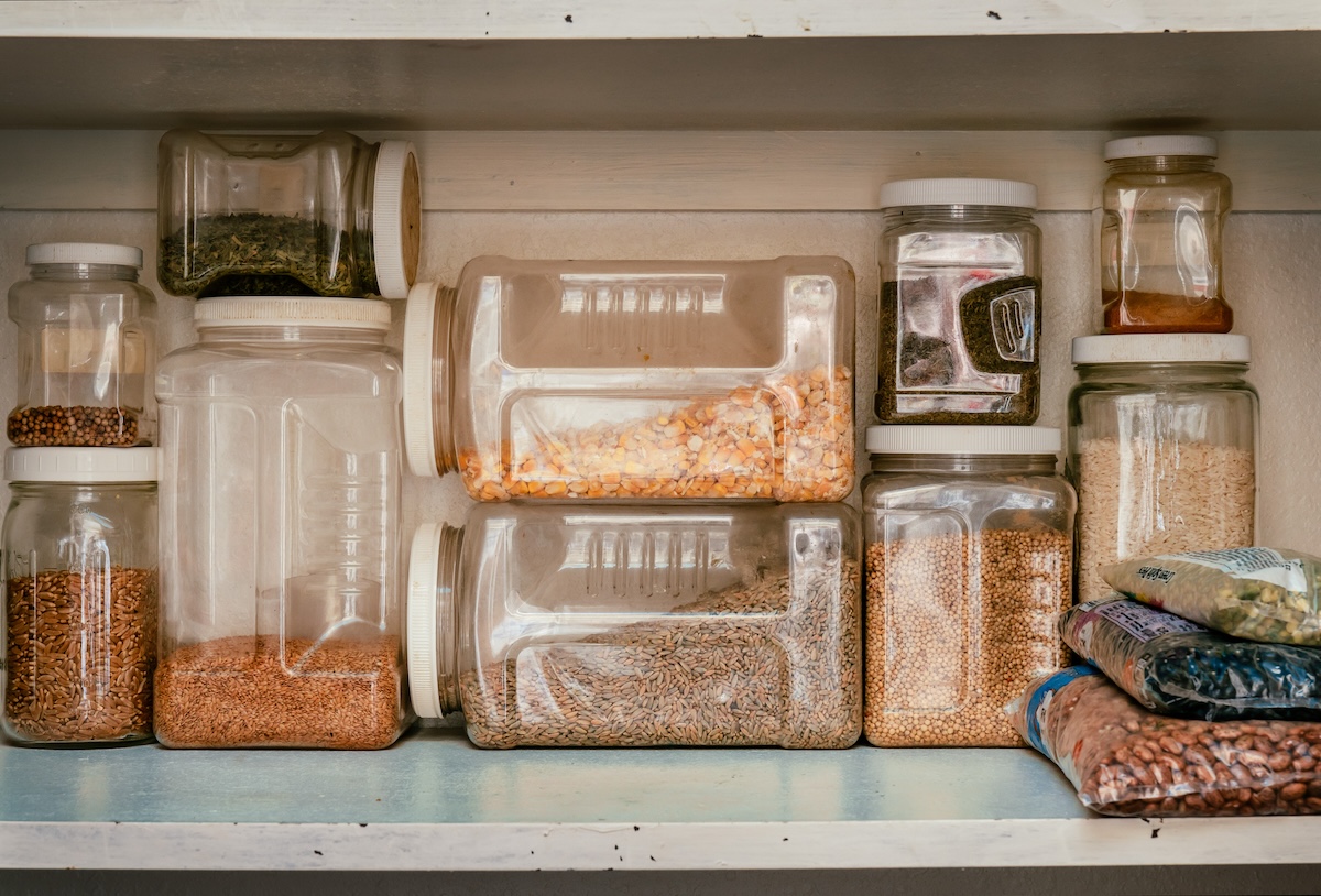 A pantry with several organized containers of dried grains.
