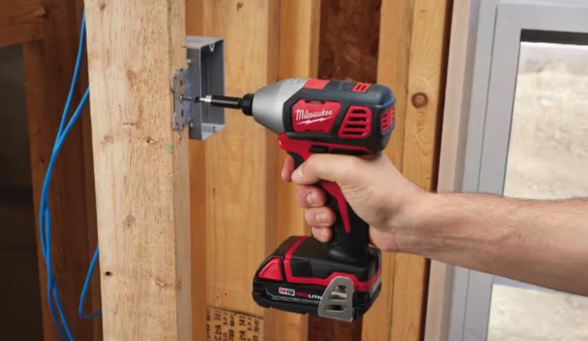 Person drilling into frame with Milwaukee impact driver