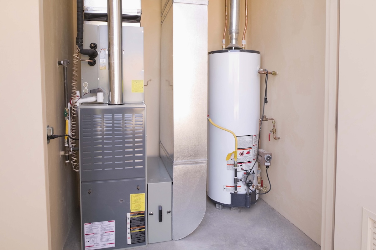 A home hot water tank next to a furnace.