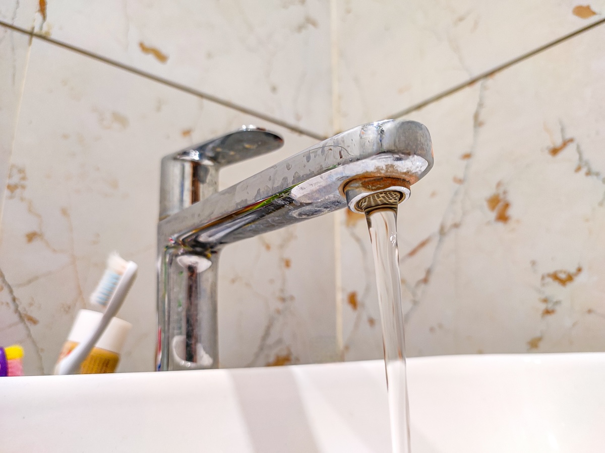 A bathroom faucet with water stains.