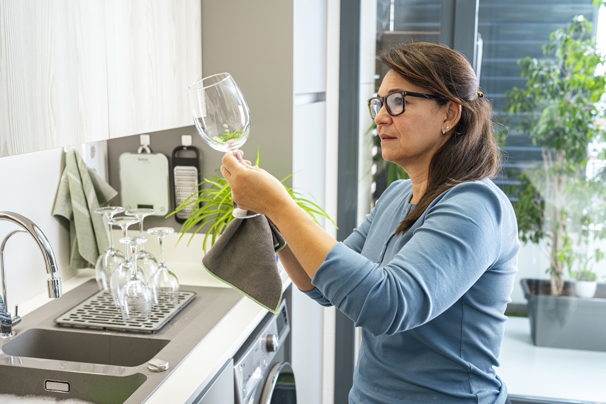 A woman looks at stained wine glasses.