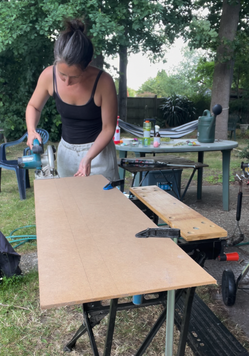 DIYer and designer Dawn Allen cutting pieces of trim for her custom hutch project.