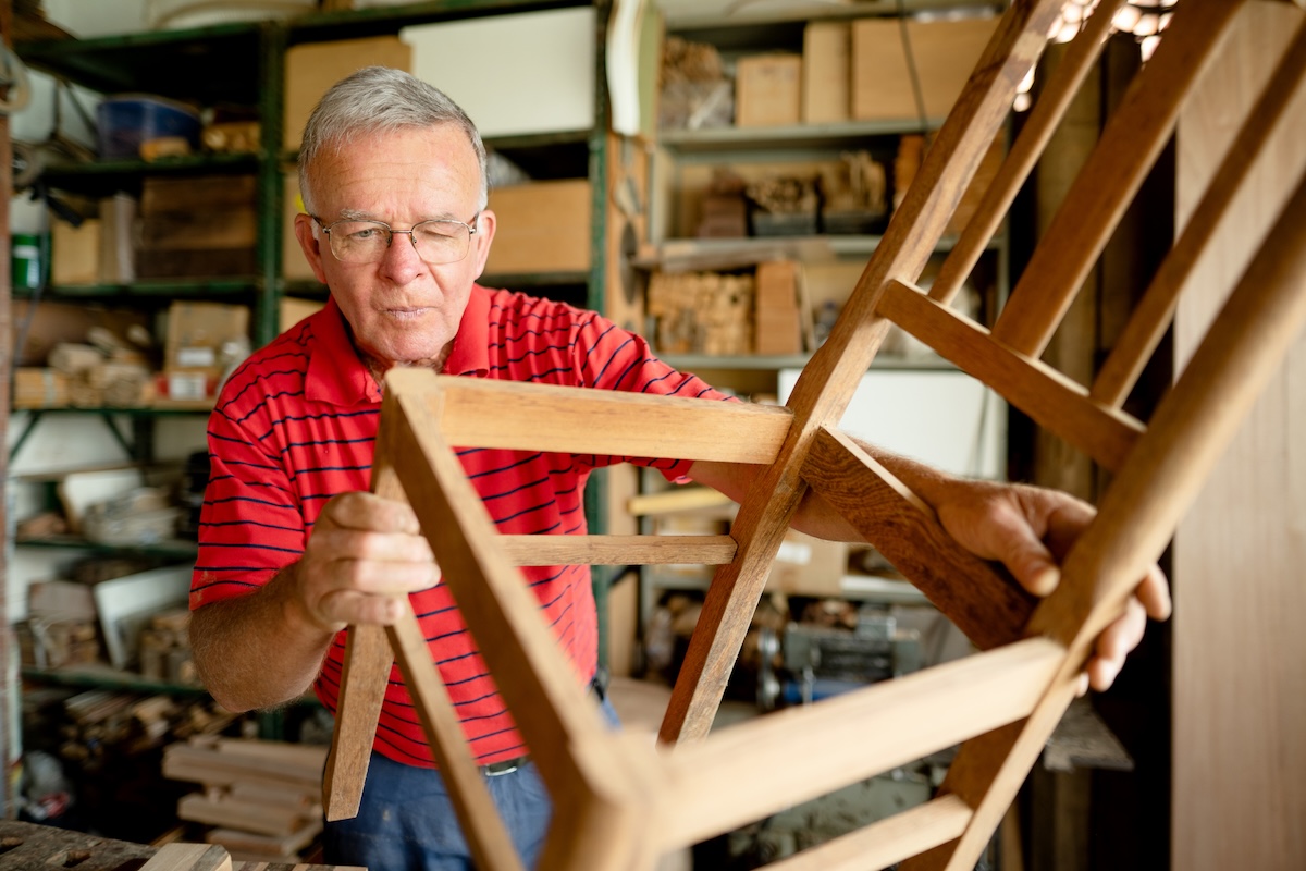 A person inspecting wood furniture before refinishing it.