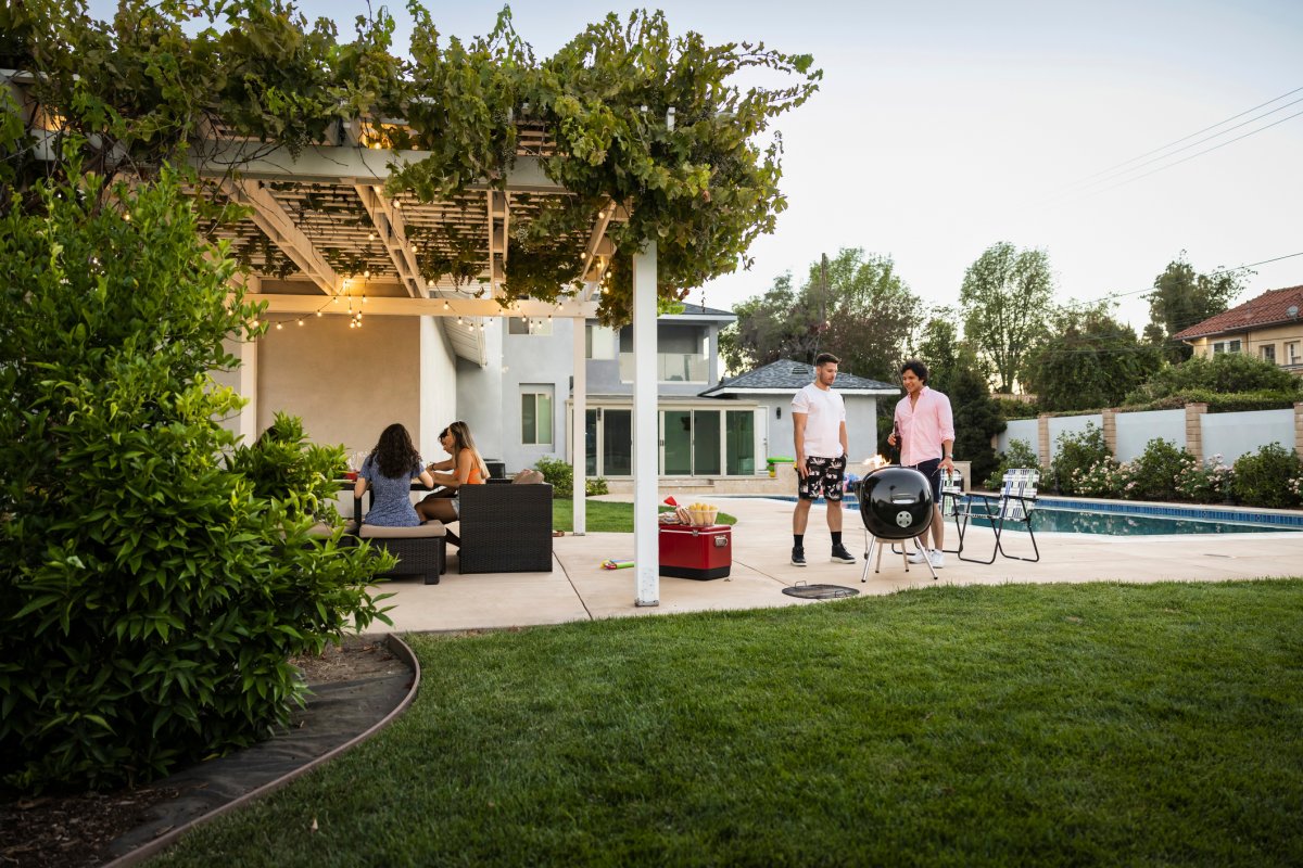 Wide view of friends enjoying party in backyard
