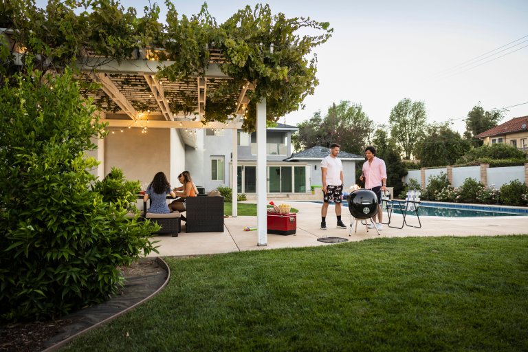 Wide view of friends enjoying party in backyard