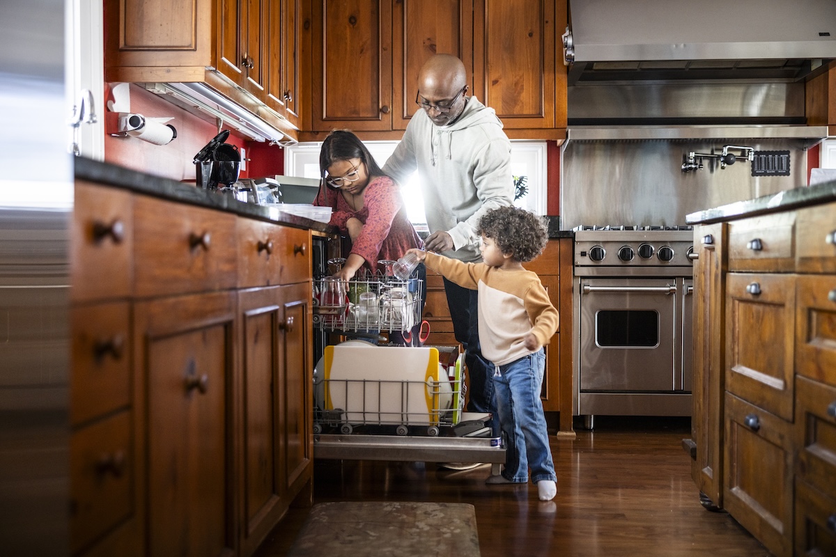 A family loading the dishwasher together.