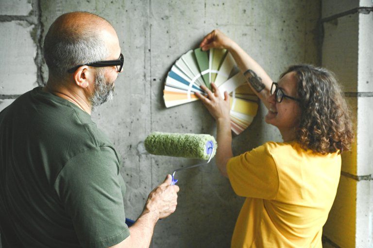 Older couple looking at paint color wand to choose a paint color for interior walls