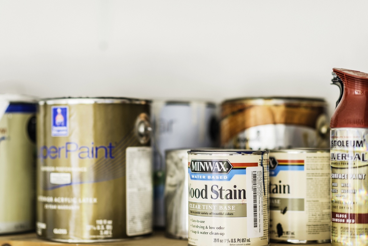 Wood finishes and paints on a garage shelf.