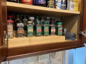Inside of organized cabinet with bamboo spice rack