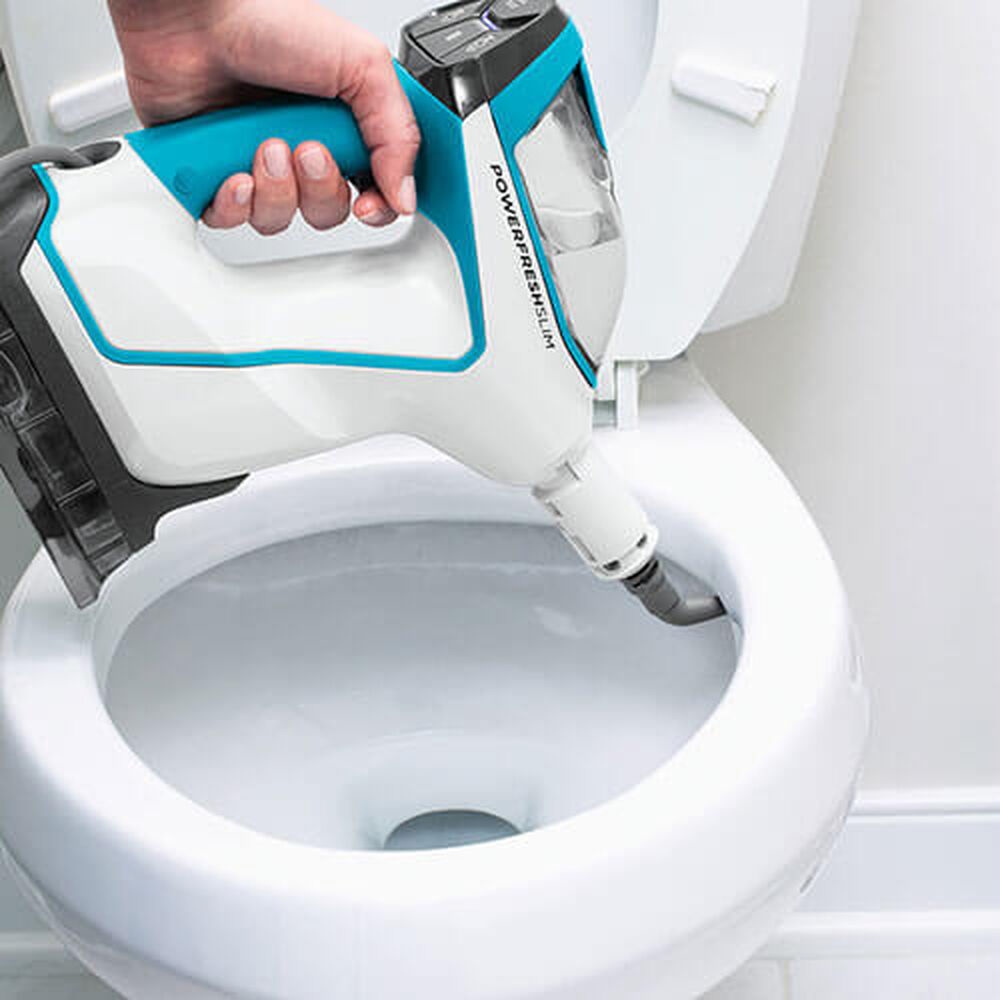 A person using a handheld steam cleaner to sanitize a toilet bowl.