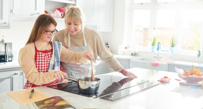 Mother and daughter cooking on an induction stove.
