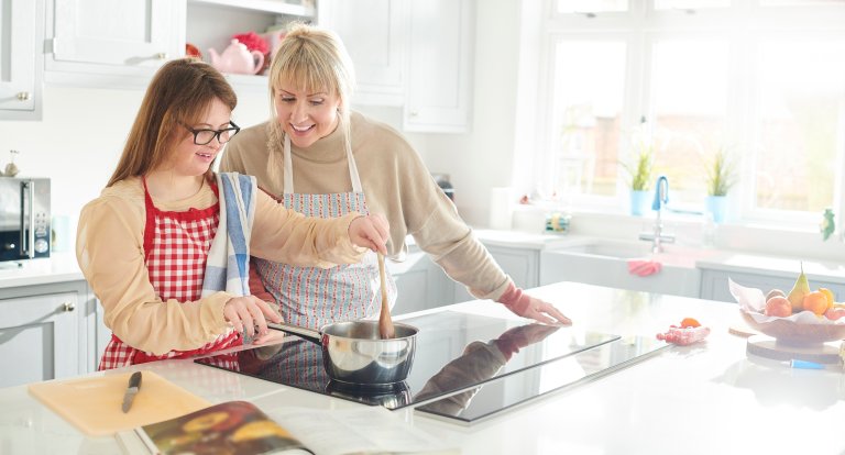 Mother and daughter cooking on an induction stove.