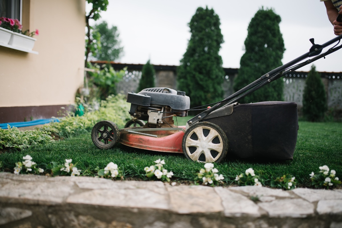 An old gas mower on a suburban lawn.