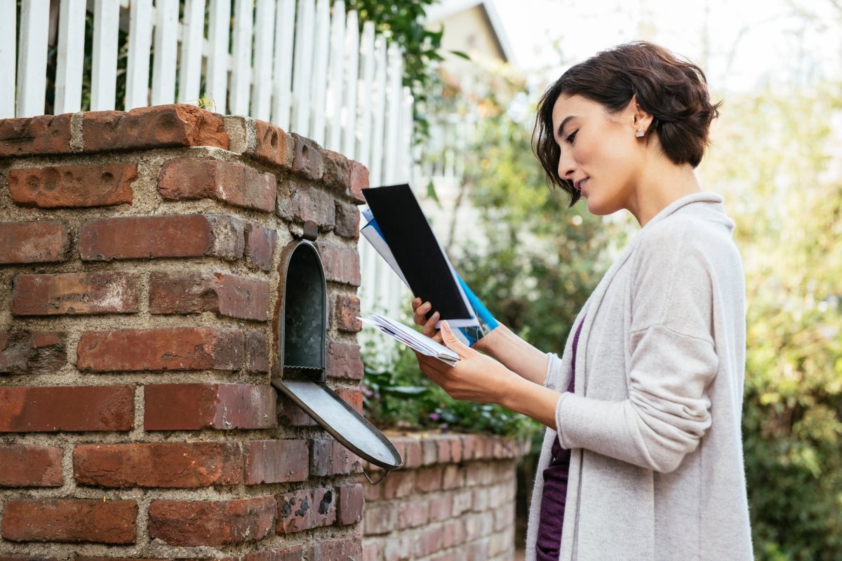 Woman checking mailbox for a neighbor.