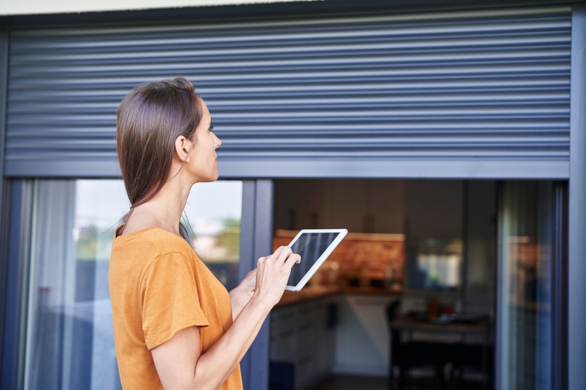 Woman using smart window treatments.