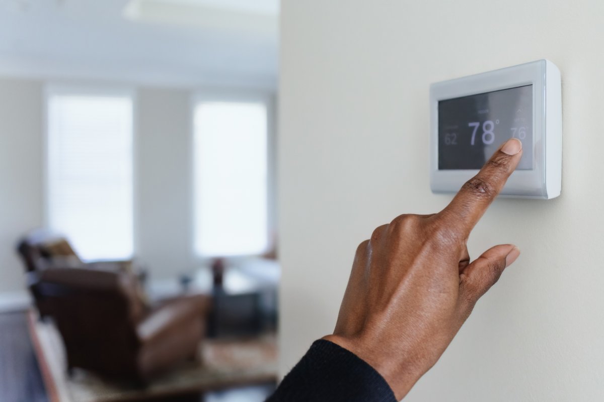 Close-up of a hand adjusting a thermostat
