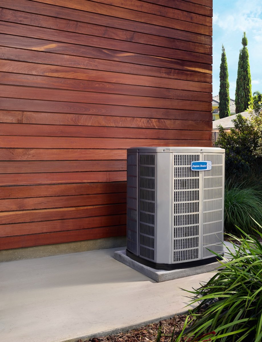 An American Standard heat pump installed outside of a residential home.