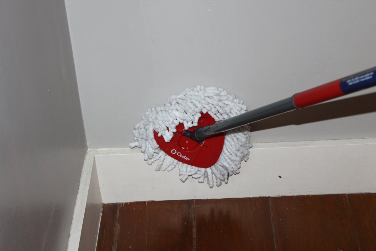 Closeup cleaning baseboards with ocedar spin mop