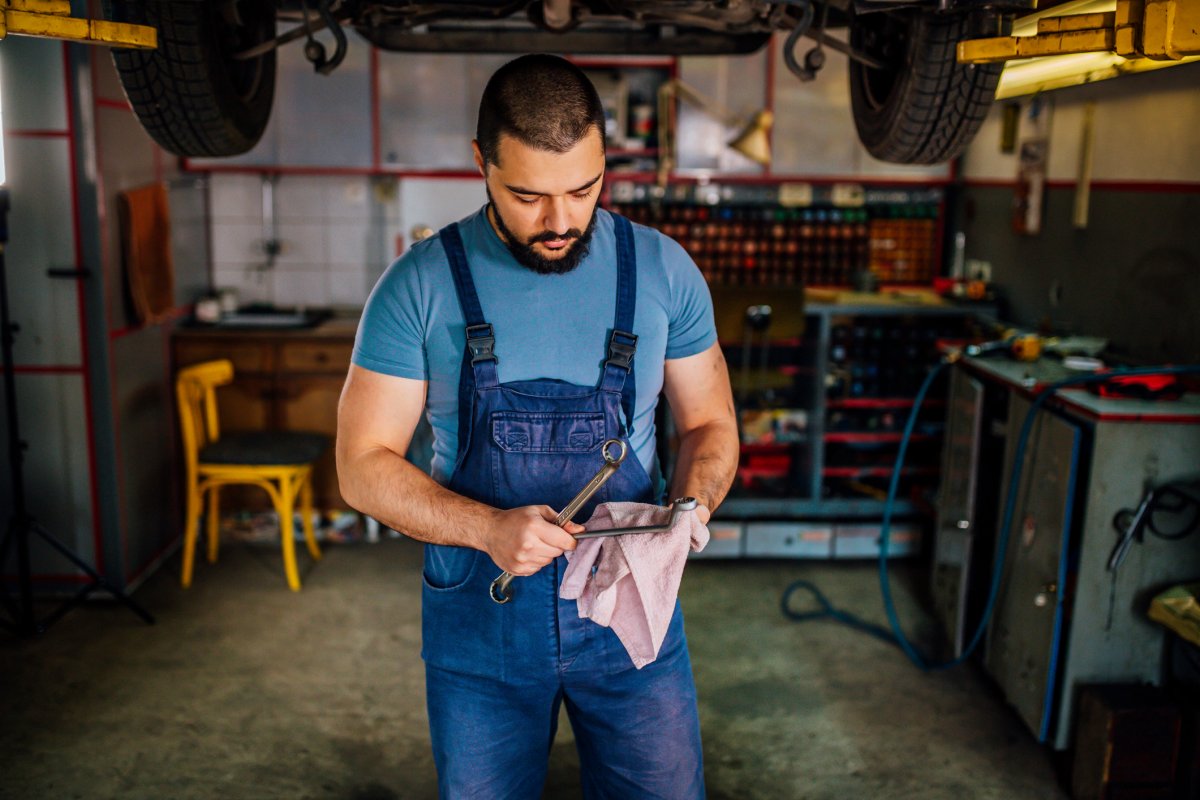 Man cleaning tools with a pink cloth