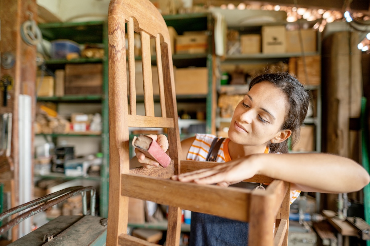 A DIYer using Bondo wood filler to repair cosmetic issues on a wood chair.